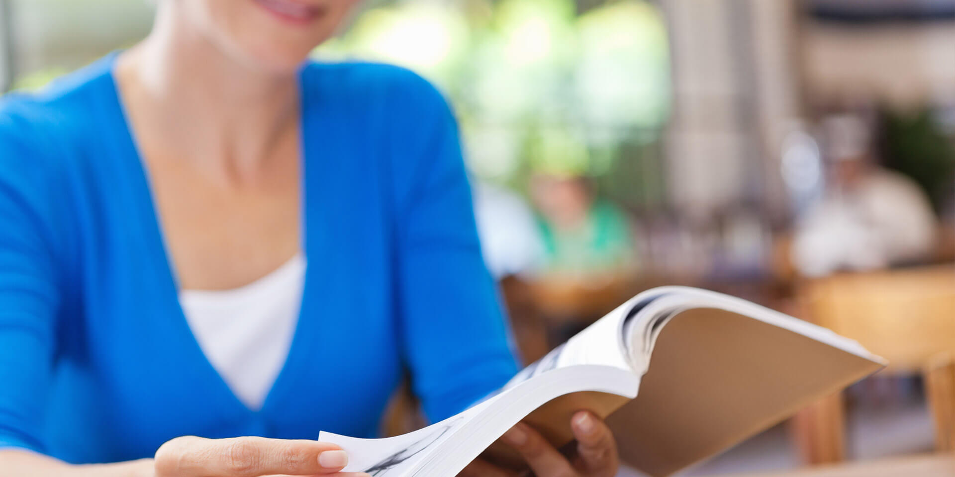 Das Bild zeigt eine Frau, die ein Buch in einer Bibliothek liest Vier Dekanate gründen gemeinsam neues Bildungswerk
