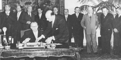 Fotographie der Vertragsunterzeichnung in Warschau mit dem stellvertretenden Staatsratsvorsitzenden der DDR, Otto Grotewohl im Vordergund.